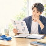 労災の症状固定後の治療やリハビリについて資料を確認する男性の水彩イラスト